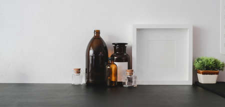 Cropped shot of modern workplace with copy space and office supplies on black table and white wall...