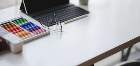 Cropped shot of comfortable designer workplace with office supplies and copy space on white table...