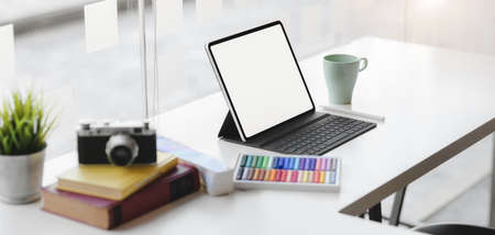 Cropped shot of modern graphic designer workplace with blank screen digital tablet, camera and...