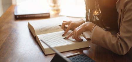 Cropped shot of young businesswoman gathering the ideas from the books for her project