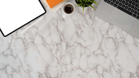 Overhead shot of modern workplace with copy space and office supplies on marble desk backgroundの写真素材