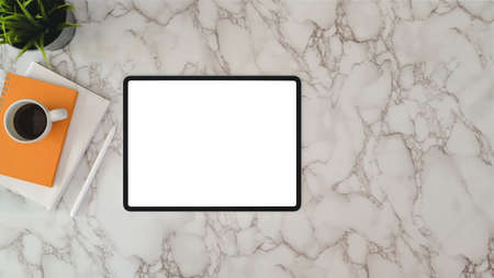 Top view of modern workplace with blank screen tablet and office supplies on marble desk background