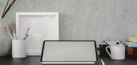 Cropped shot of modern office room with blank screen digital tablet and office supplies on black tableの写真素材