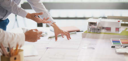 Cropped shot of young professional architect team working on their project together in modern office...