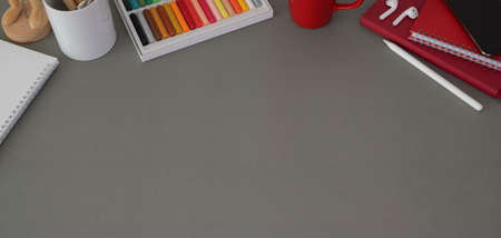Top view of modern workplace with laptop computer and office supplies on dark grey table background