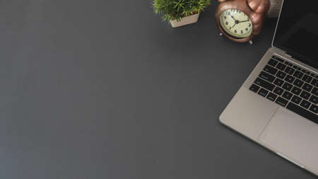 Top view of modern workplace with copy space and office supplies on dark grey backgroundの写真素材