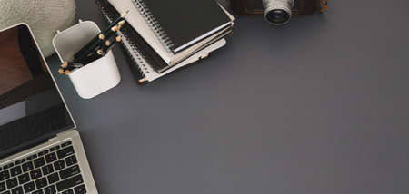 Top view of modern workplace with laptop computer and office supplies on dark grey table backgroundの写真素材