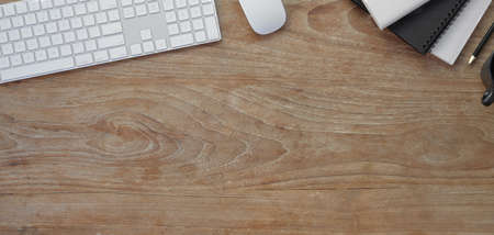 Top view of comfortable workplace with office supplies and copy space on wooden table background