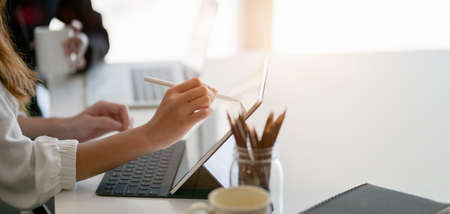 Cropped shot of businesswoman working on their project together with digital tablet in modern office roomの写真素材
