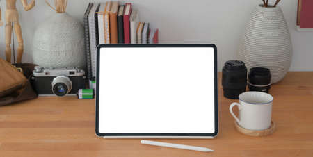 Cropped shot of comfortable photographer workplace with blank screen digital tablet and office...
