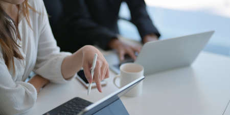 Cropped shot of passionate businesswomen working on the project together while using tablet の写真素材