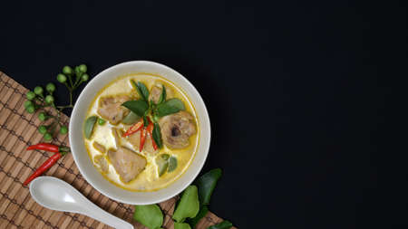 Thai cuisine concept : chicken green curry and ingredients on black desk background with copy spaceの写真素材