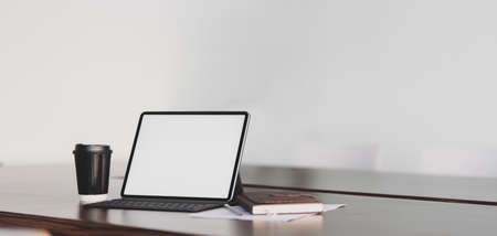 Close-up view of modern office room with blank screen tablet with office supplies and coffee cupの写真素材