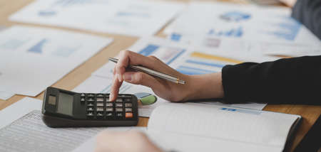 Cropped shot of young professional accountant summarising current financial status by document 