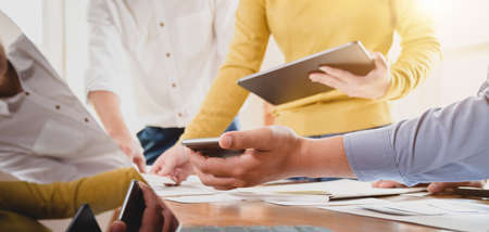 Close-up view of young professional UX web developer team discussing on the project together 