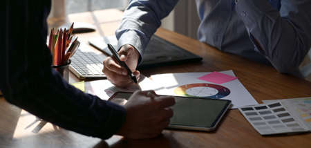 Cropped shot of young graphic designer discussing the project together in comfortable workplaceの写真素材