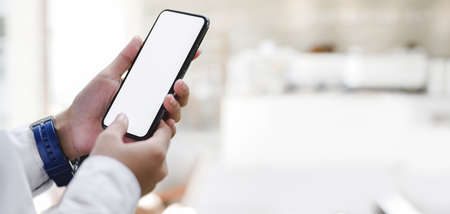 Cropped shot of young businesswoman working on her project while using smartphone in her workplace の写真素材