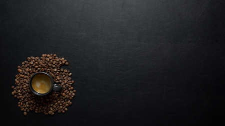 Top view of coffee cup and coffee beans on black table background with copy spaceの写真素材