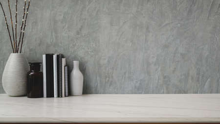 Close up view modern workspace with copy space, ceramic vases and books on marble desk with  grey...