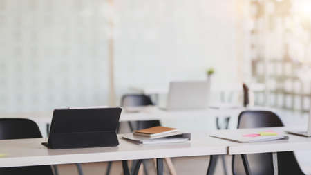 Cropped shot of modern office room with digital tablet and office supplies on white desk with blurred backgroundの写真素材