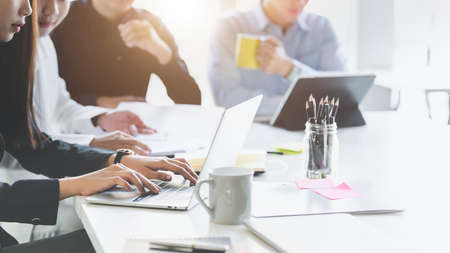Cropped shot of business group concentrating on their project while siting in simple meeting room...
