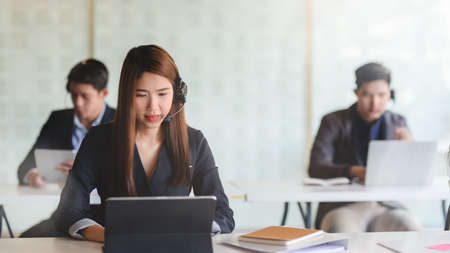 Close up view of female customer service sitting in line call centre operation and   talking on...