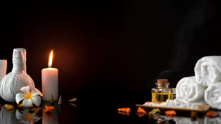 Beautiful spa composition with spa accessories on black massage table and dark background の写真素材