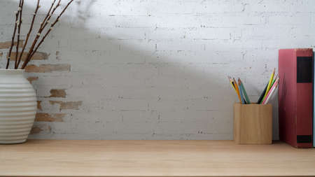 Close up view of contemporary workspace with stationery, decorations and copy space on wooden desk...