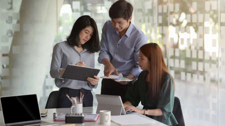 Close up view of young professional designer team focusing on their project  in simple co working...
