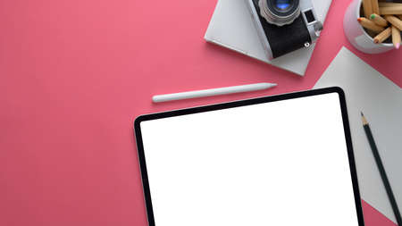 Overhead shot of stylish designer workspace with mock up tablet, camera, stationery and copy space...