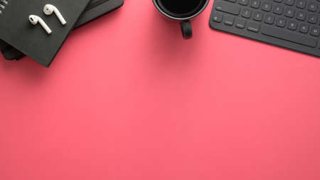 Top view of stylish workspace with digital tablet, office supplies and copy space on pink table backgroundの写真素材