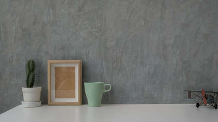 Close up view of modern workspace with coffee cup, copy space and decorations on white table with...