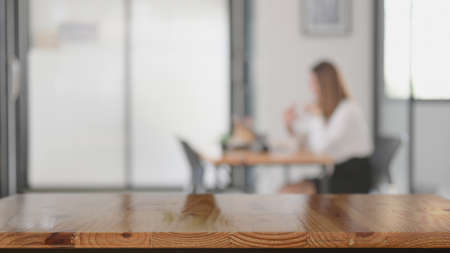 Close up view of copy space on wooden table with blurred co-working space backgroundの写真素材