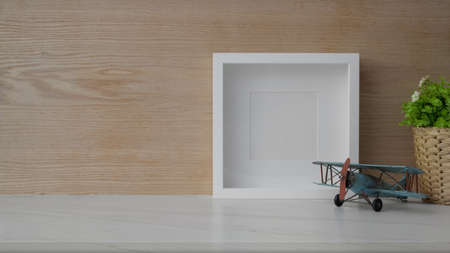 Close up view of simple workplace with copy space, mock up frame and decorations on marble desk with...