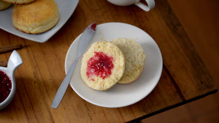 Cropped shot of Traditional English afternoon tea, Scones with strawberry jam on wooden tableの写真素材