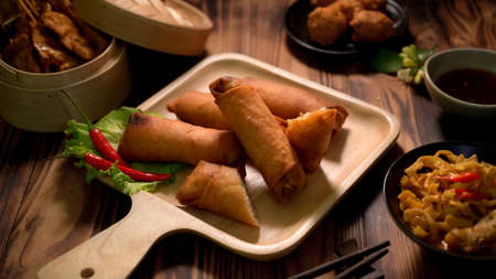 Cropped shot of Thai traditional street food with fried spring rolls and Thai appetisers on wooden...