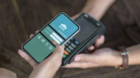 Close up view of male customer using smartphone for online payment by online banking application 