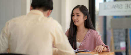 Cropped shot of University students reading together in modern co-working spaceの写真素材