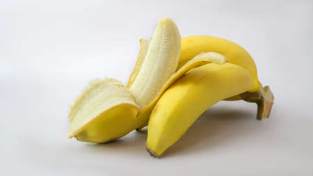 Close up view of bunch and peeled of bananas, tropical fruit isolated on white background の写真素材