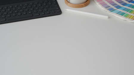 Cropped shot of minimal designer workspace with tablet, colour swatch and copy space on white table の写真素材