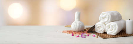 Cropped shot of Spa accessories with white towel, candle, herbal compressing ball and copy space on marble tableの写真素材