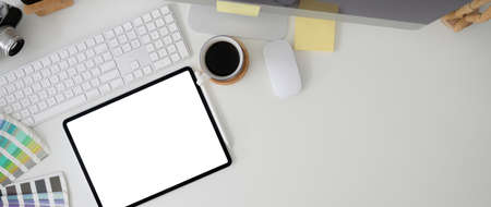Overhead shot of stylish workspace with mock-up tablet, computer device, designer supplies and copy space on white tableの写真素材