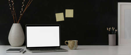 Cropped shot of dark modern workspace with mock-up laptop, stationery, decorations and copy space on marble desk  の写真素材