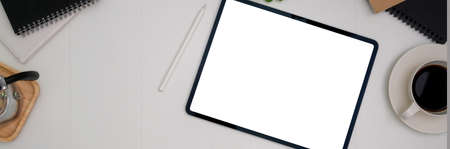 Top view of simple workspace with mock-up tablet, coffee cup and copy space on white table   