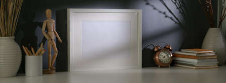 Close up view of stylish home office with blank screen laptop, books, decoration and copy space on...