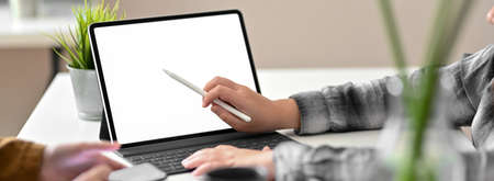 Cropped shot of businesspeople consulting on their work with mock-up tablet and smartphone at modern office roomの写真素材