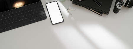 Top view of simple workspace with blank screen smartphone, tablet ,office supples and copy space on...