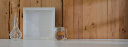 Close up view of modern rustic workspace with tea cup, decorations and copy space on white table...