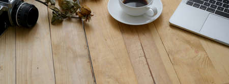 Cropped shot of modern rustic workspace with laptop, coffee cup, decoration and copy space on wooden...