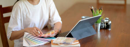 Cropped shot of female university student working on her project and choosing colour on colour...